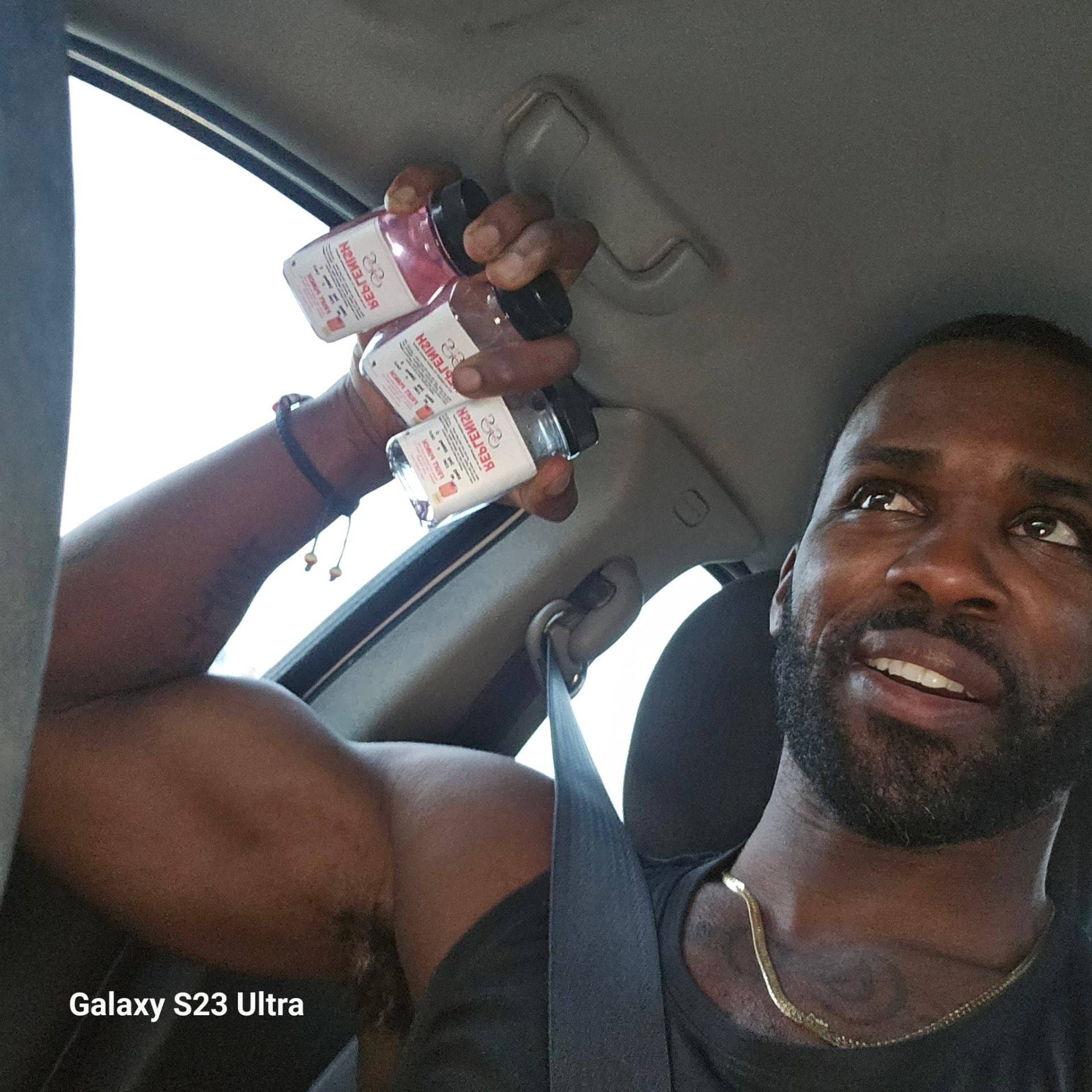 Coach holding three REPLENISH hydration bottles